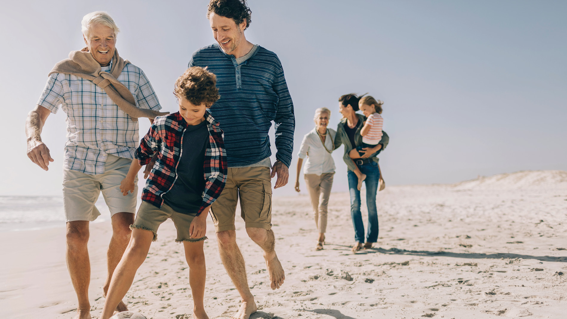 Familie wandelend op het strand