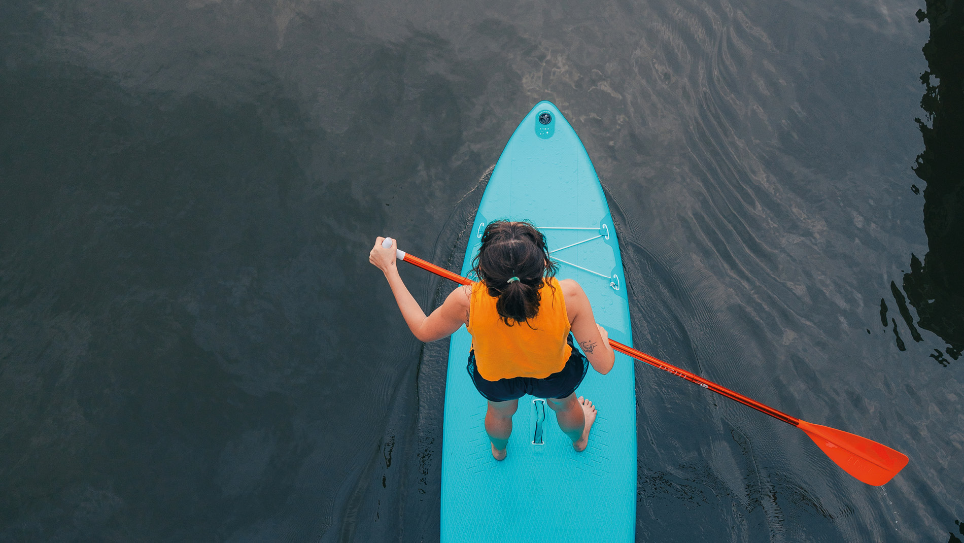 Bovenaanzicht van vrouw op blauw surfboard